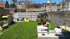 A courtyard with a swimming pool, outdoor seating, and a stone wall. - L'Âme Du Gourmand (Pontorson)