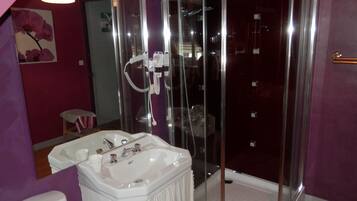 A bathroom with a glass-enclosed shower, a white sink, and a toilet.