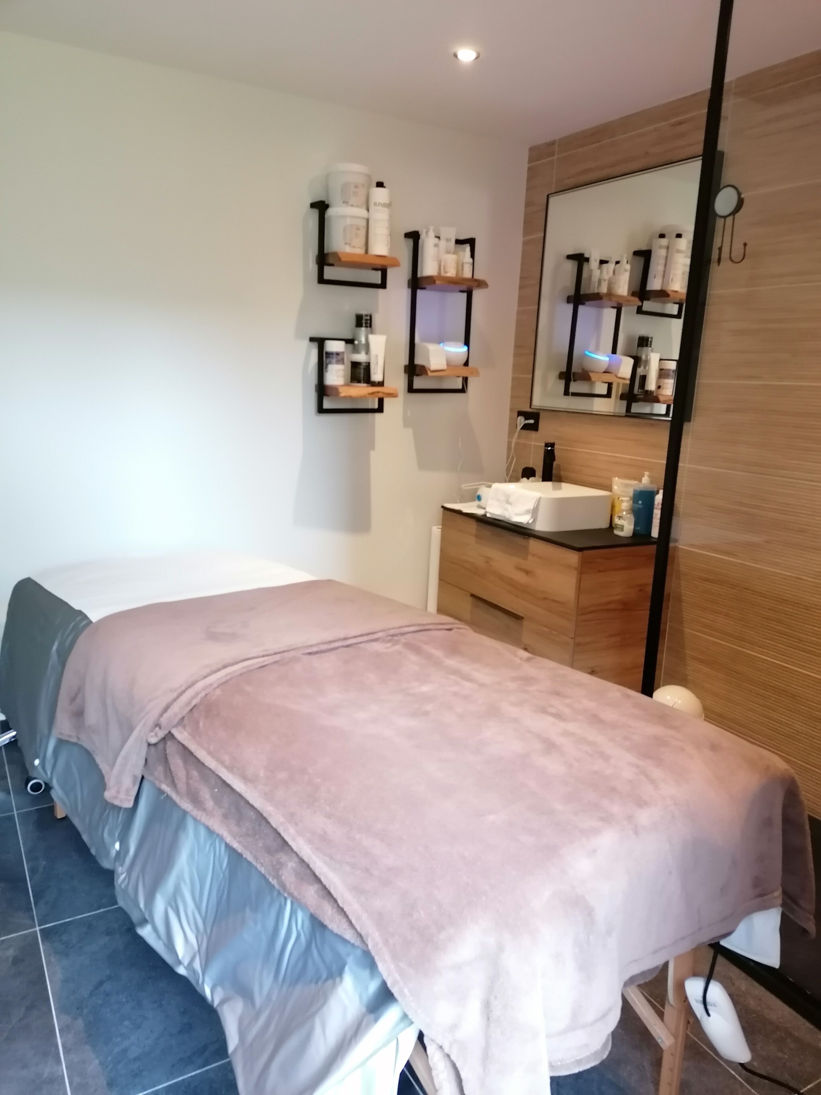Ein modernes Zimmer mit einem Bett, einem Holzinlay für Schminkutensilien und Regalen mit Toilettenartikeln.