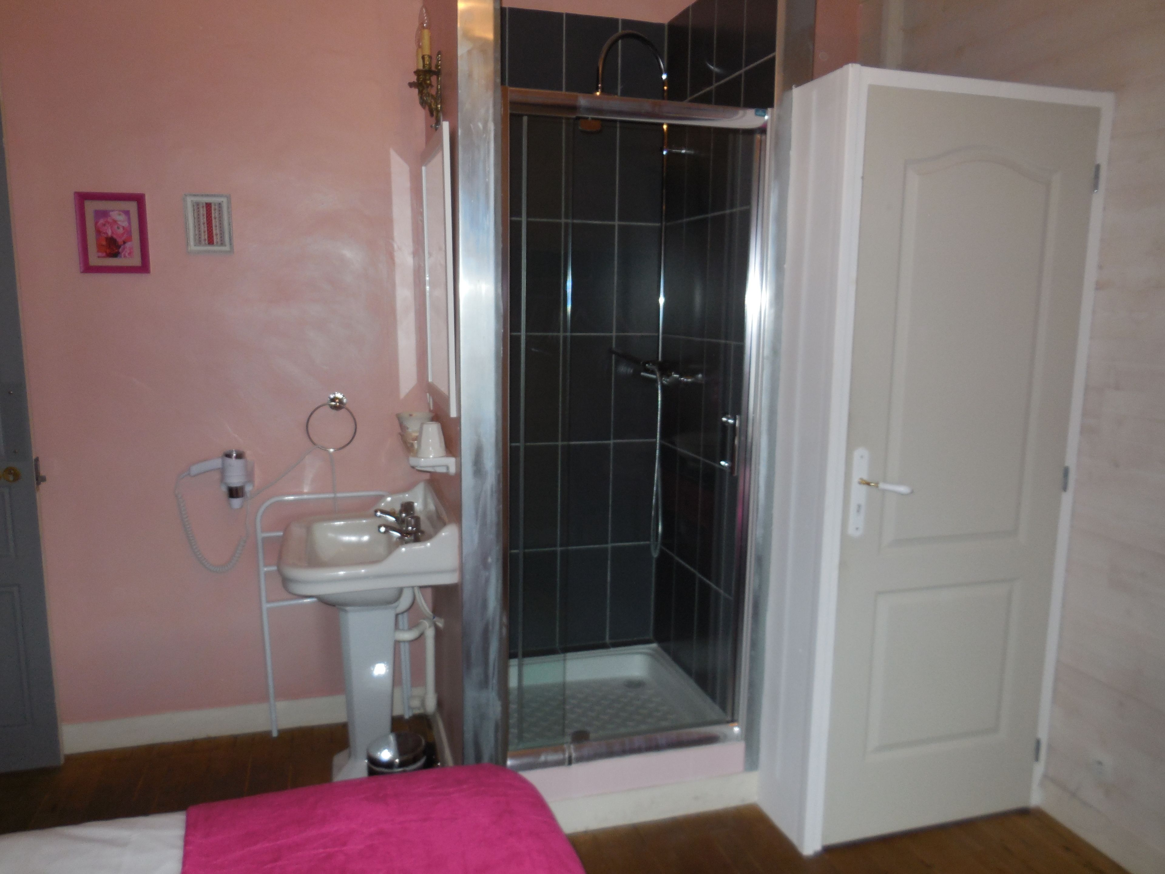 A bathroom with a shower, sink, and toilet.