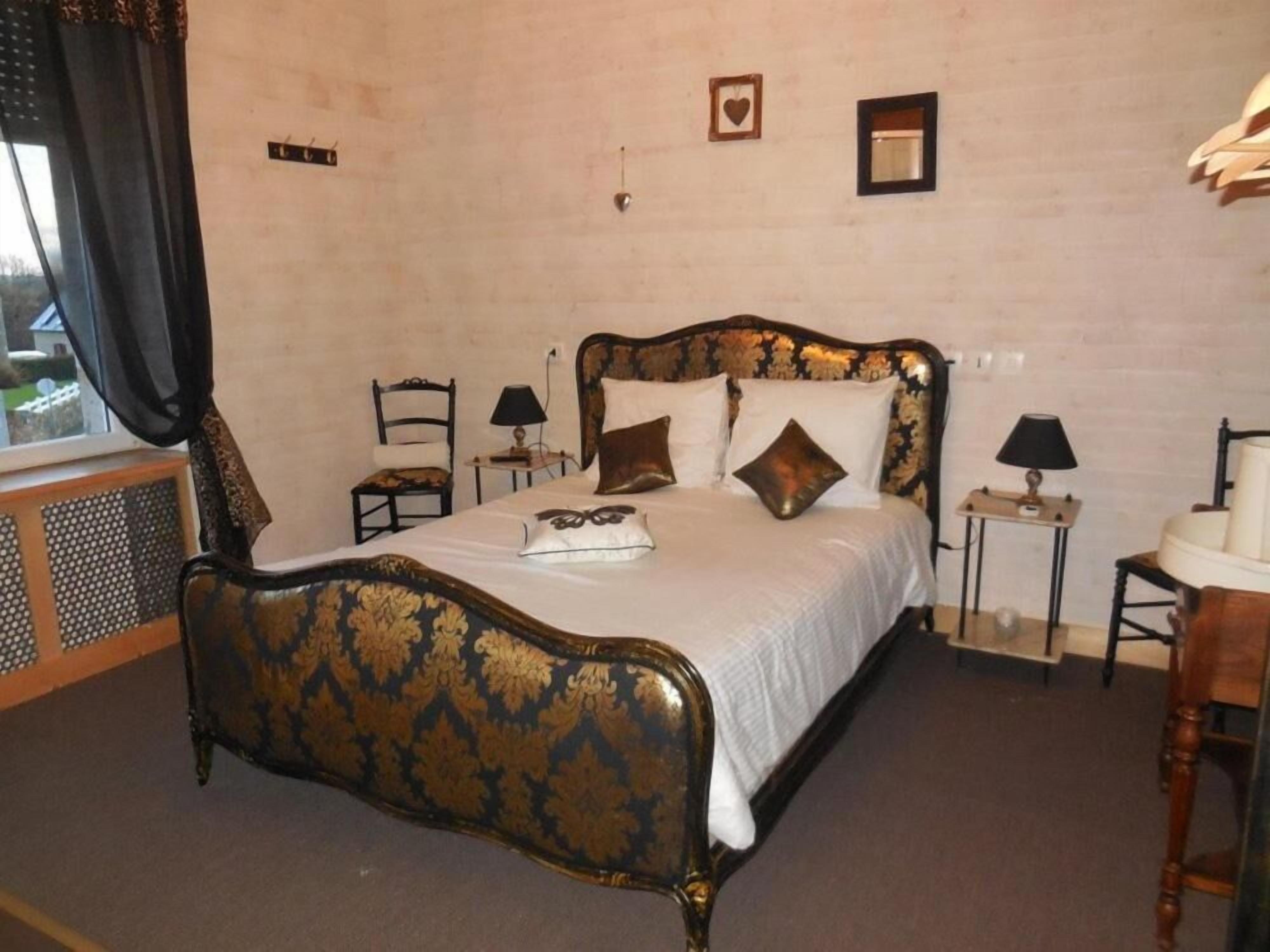 Une chambre à coucher avec un lit à baldaquin, deux tables de chevet avec des lampes, un fauteuil et une fenêtre avec des rideaux.