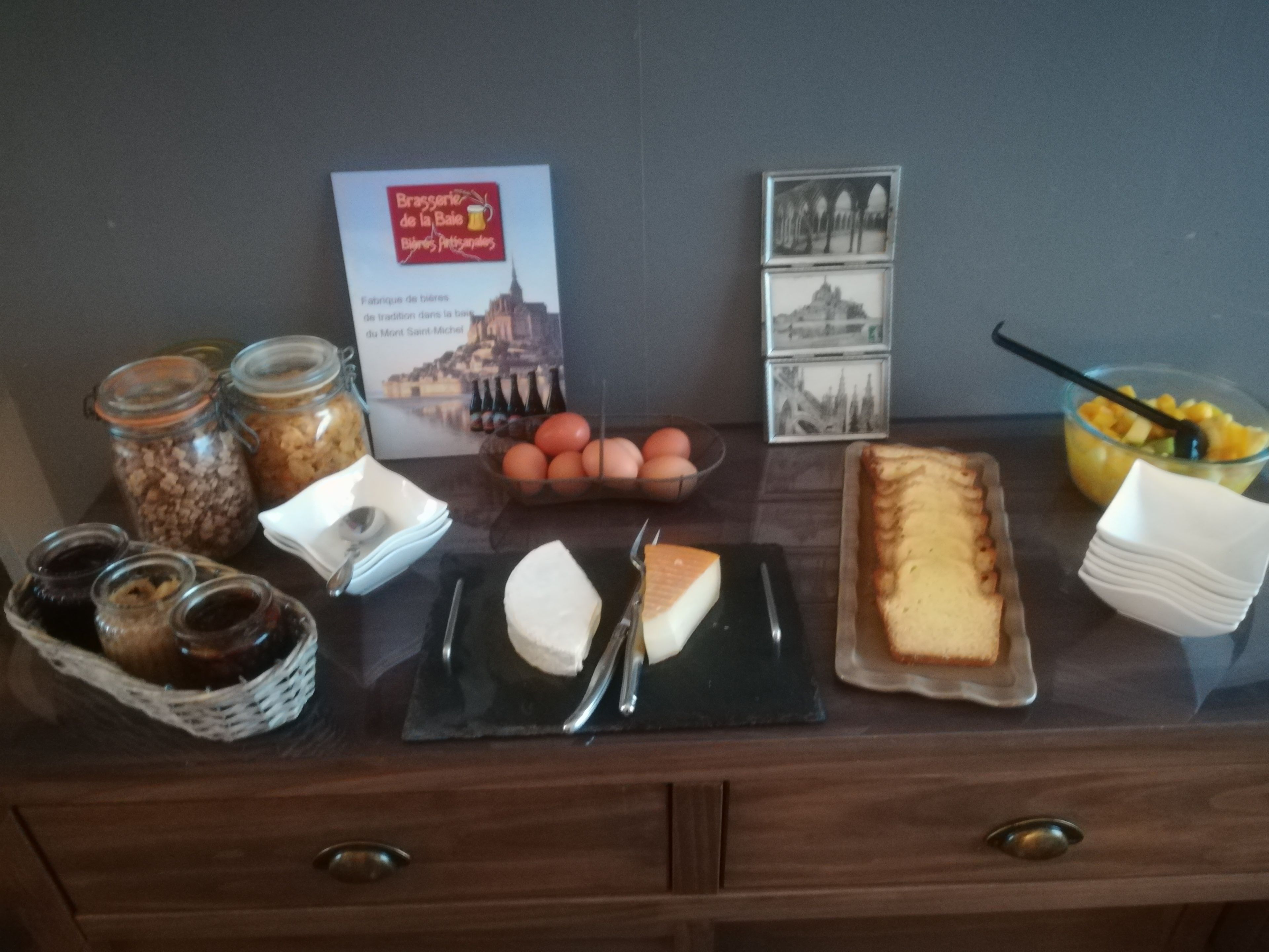 A breakfast buffet with various food items, including cheese, bread, and fruits.