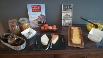 Un ricco buffet per la colazione con formaggi, pane e frutta.