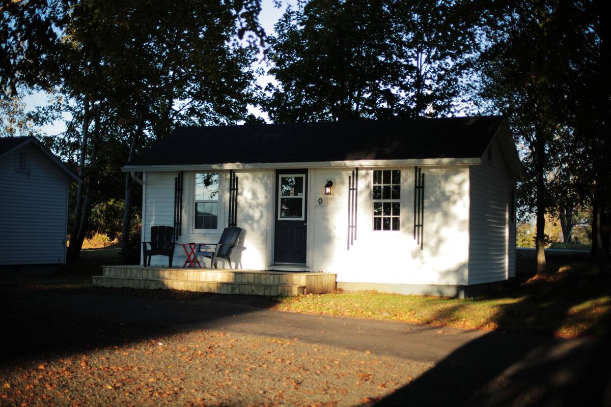 A single-story house with a front porch, a door, and a small window.