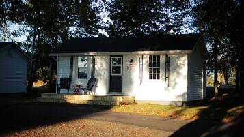 A single-story house with a front porch, a door, and a small window.