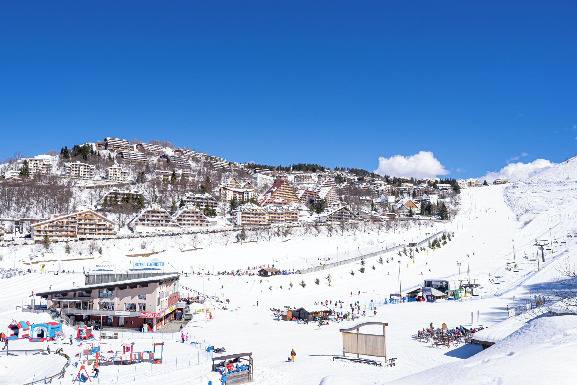 A snow-covered ski resort with multiple buildings, including a hotel and a school.