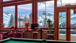 A pool table with a view of snow-capped mountains through large windows. - Hotel Mondolè (Frabosa Sottana)