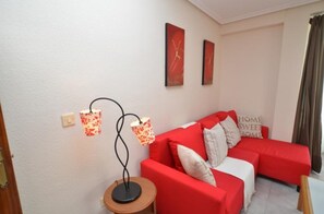 Relax in a stylish living area with a sofa, artworks, and a floor lamp.
