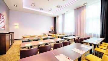A conference room with multiple tables and chairs, a podium, and a large window with curtains.