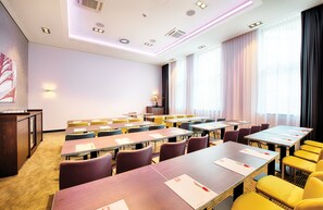 A conference room with multiple tables and chairs, a podium, and a large window with curtains. - Leonardo Royal Hotel Ulm (Ulm)