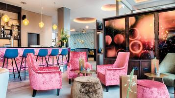 A modern bar area with seating and a large window with a view of the city.