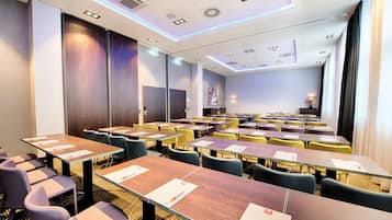 A conference room with multiple tables and chairs, equipped with nameplates and pens.