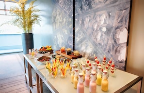 A buffet table with various food items and beverages.