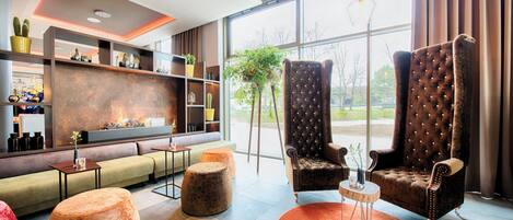 Un interior moderno con una zona de estar, chimenea y ventanas amplias.
