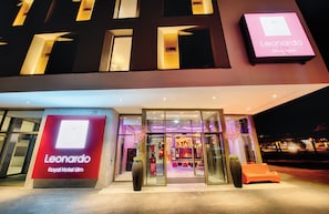 Exterior del Hotel Leonardo Royal Ulm, con entrada de vidrio y un cartel.