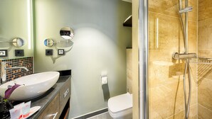 A bathroom with a large sink, a mirror, a toilet, and a shower. - Leonardo Royal Hotel Ulm (Ulm)