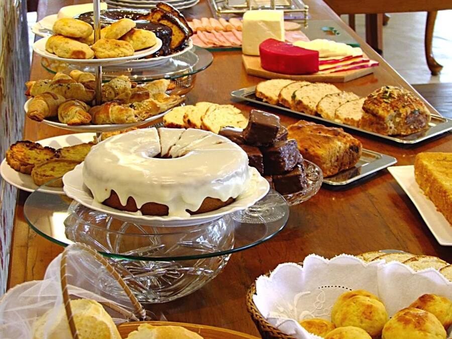 A buffet table with various food items, including cakes, pastries, and bread.