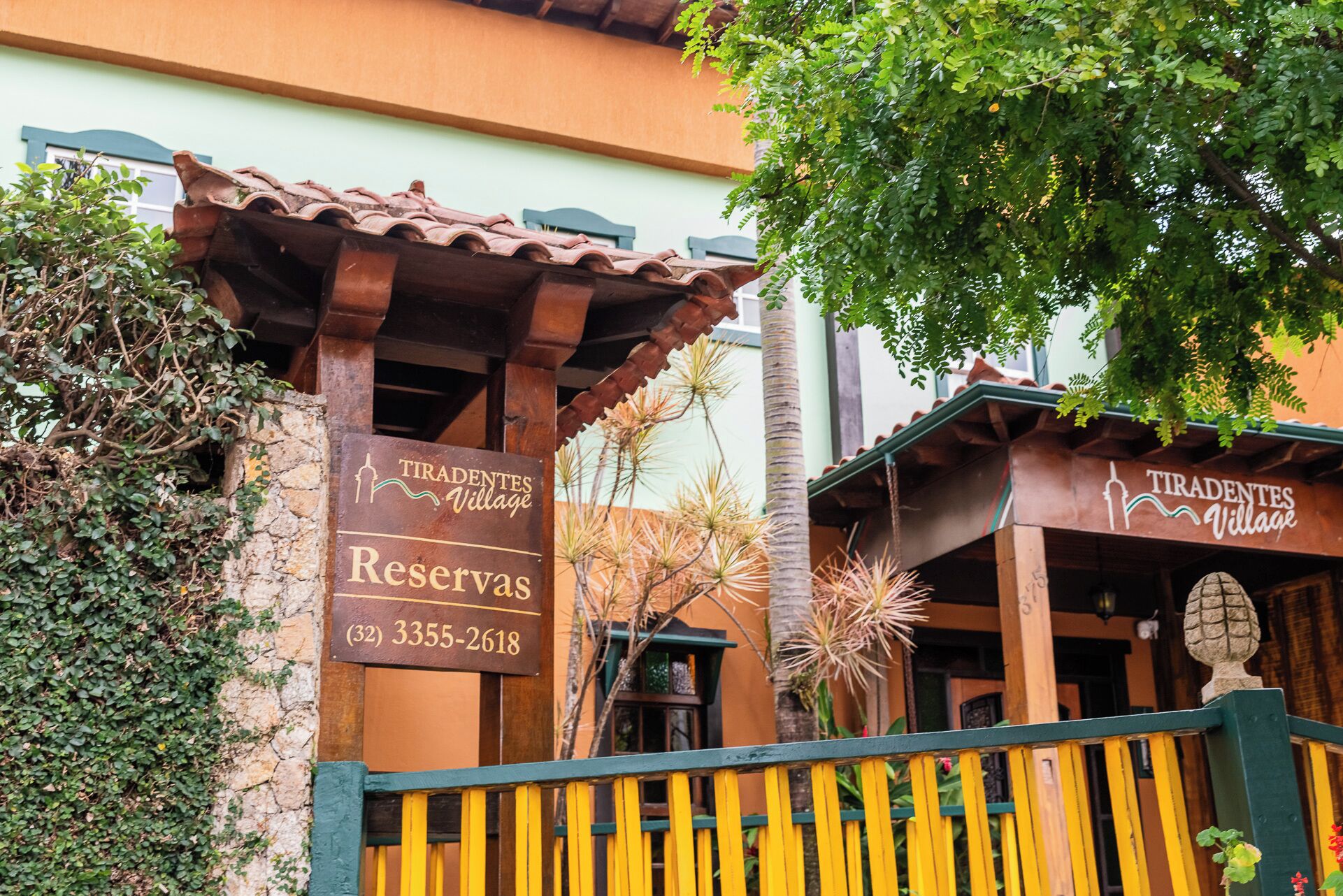 Señalización para 'Tiradentes Village Reserves' con información de contacto.