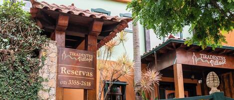 Señalización para 'Tiradentes Village Reserves' con información de contacto.