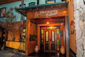 Entrada de um edifício com uma placa indicando 'TIRADENTES Village' e o número 375.
