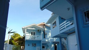 A two-story residential building with a balcony, a garage, and a paved driveway. - Pousada Estrela Guia (Florianópolis)
