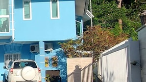 A blue building with a car parked in front. - Pousada Estrela Guia (Florianópolis)
