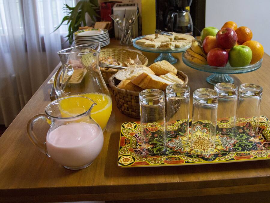 A breakfast table with various food items, a pitcher of orange juice, and a decorative plate.