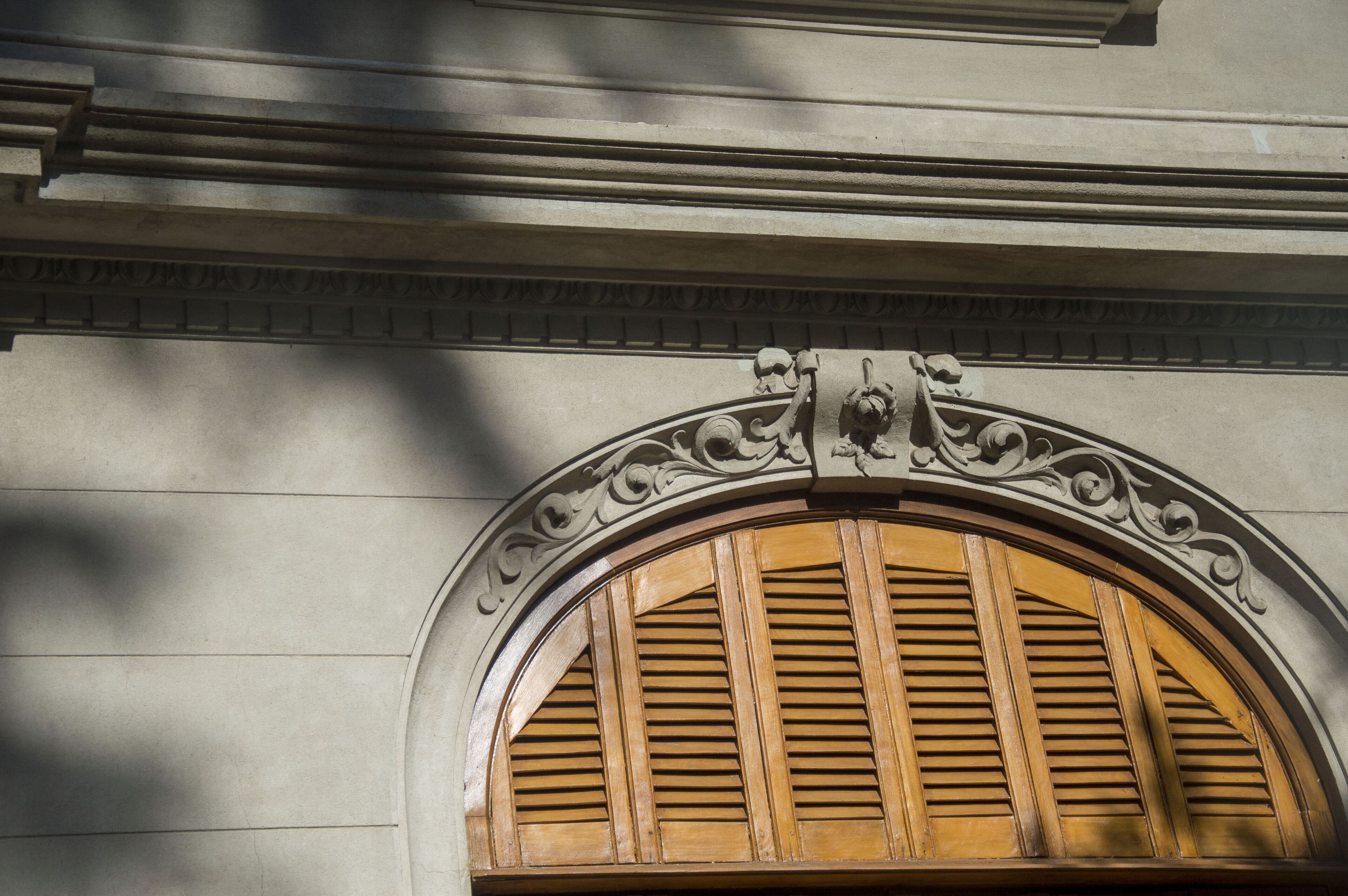 Un detalle arquitectónico con un arco decorativo y contraventanas de madera.