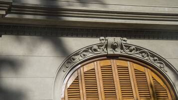 Un detalle arquitectónico con un arco decorativo y contraventanas de madera.