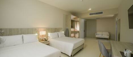 A hotel room with two beds, a desk, and a chair.