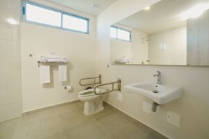 Un baño con inodoro, lavamanos y espejo.