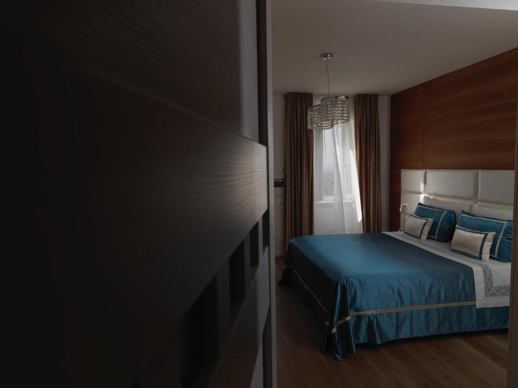 Ein Schlafzimmer mit einem Bett, Vorhängen und einer Pendelleuchte.