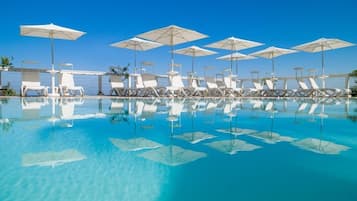 A pool area with lounge chairs and umbrellas.