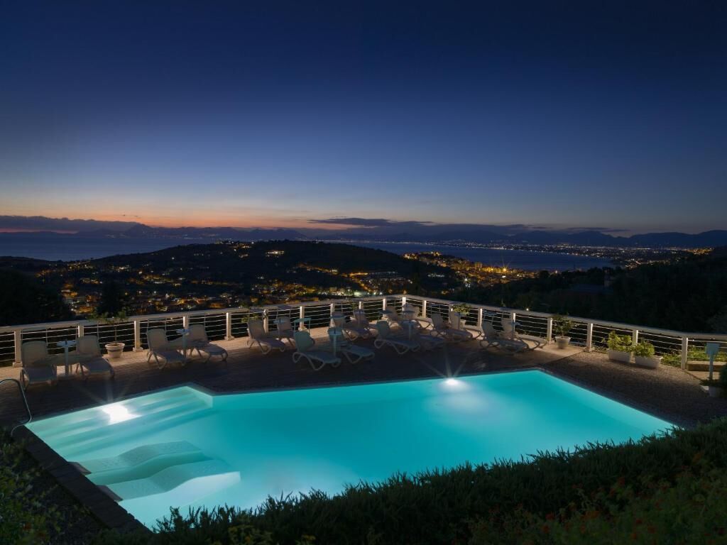 A swimming pool with a view of a cityscape at dusk.