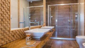 Une salle de bain moderne avec un meuble-lavabo en bois, deux vasques, une douche en verre et des toilettes.