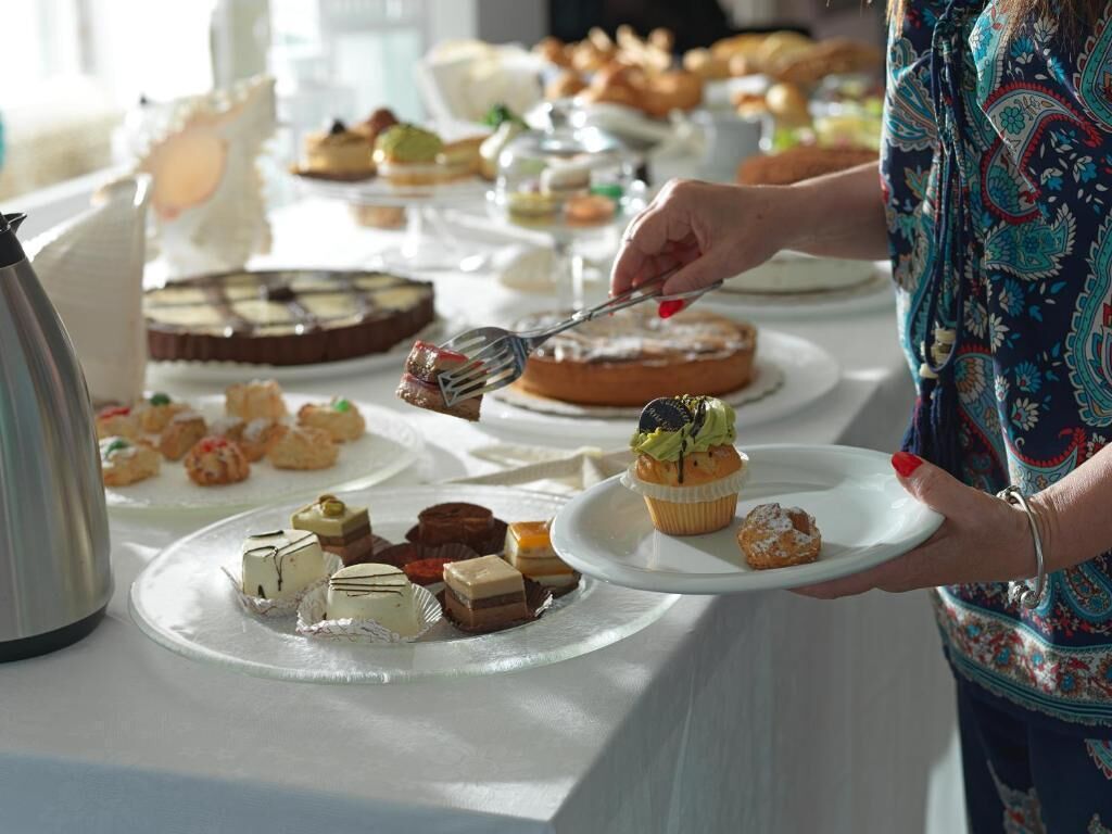A buffet table with various desserts and pastries.
