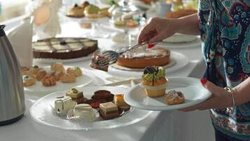 A buffet table with various desserts and pastries.