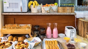 Un bufé de desayuno con diversos pasteles, pan y bebidas.