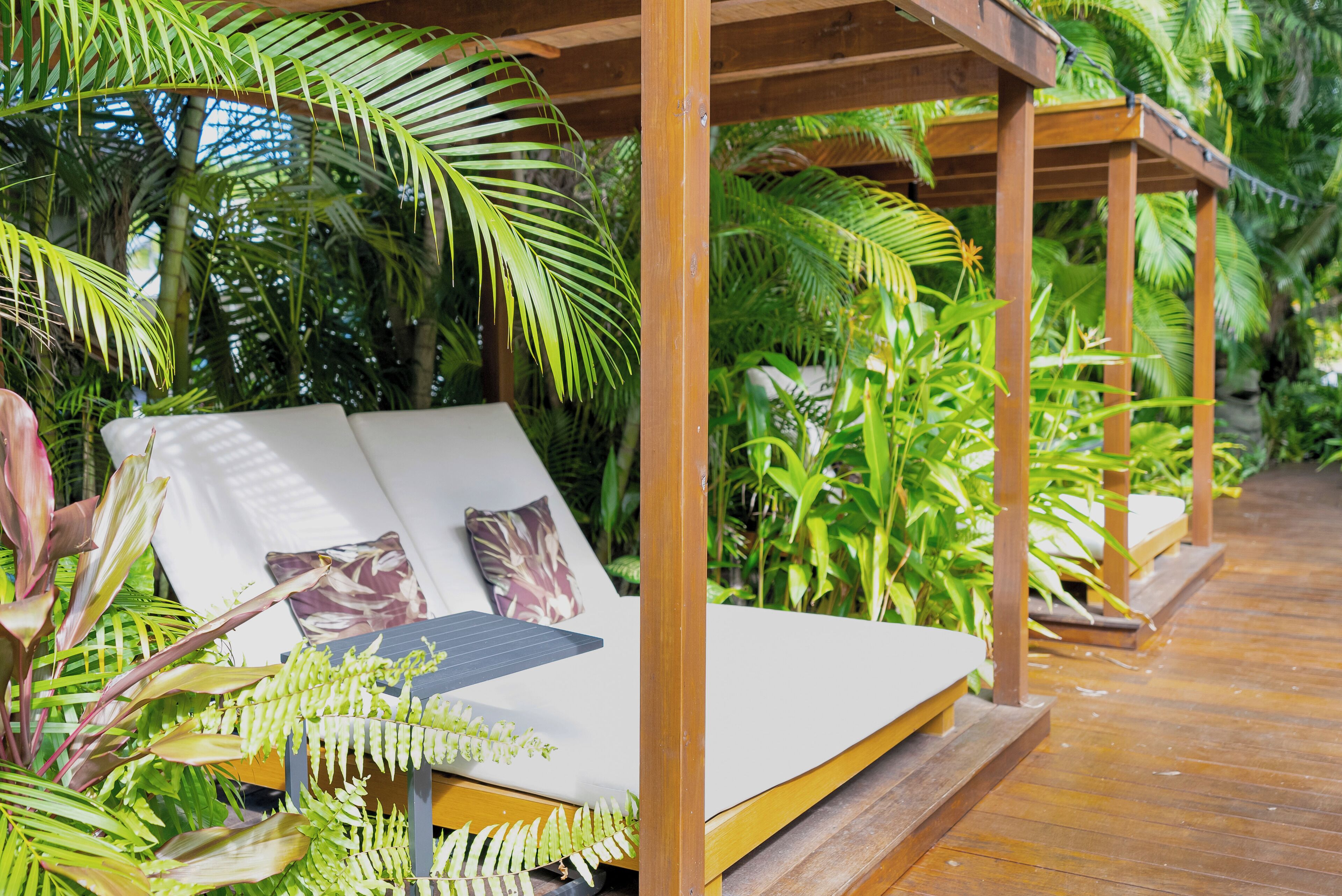 A wooden deck with a built-in bench and a small table with a solar panel.