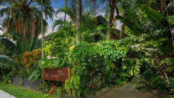 A lush garden with a sign reading "The Palms."