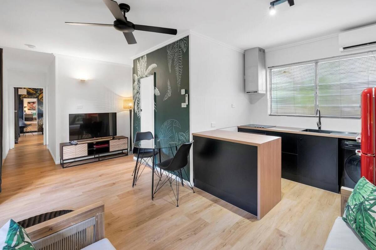 A modern living space with a kitchen, dining area, and entertainment setup.
