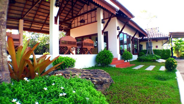 A traditional-style building with a covered porch, stone steps, and well-maintained greenery. - Khum Nakhon Hotel (Nakhon Si Thammarat)