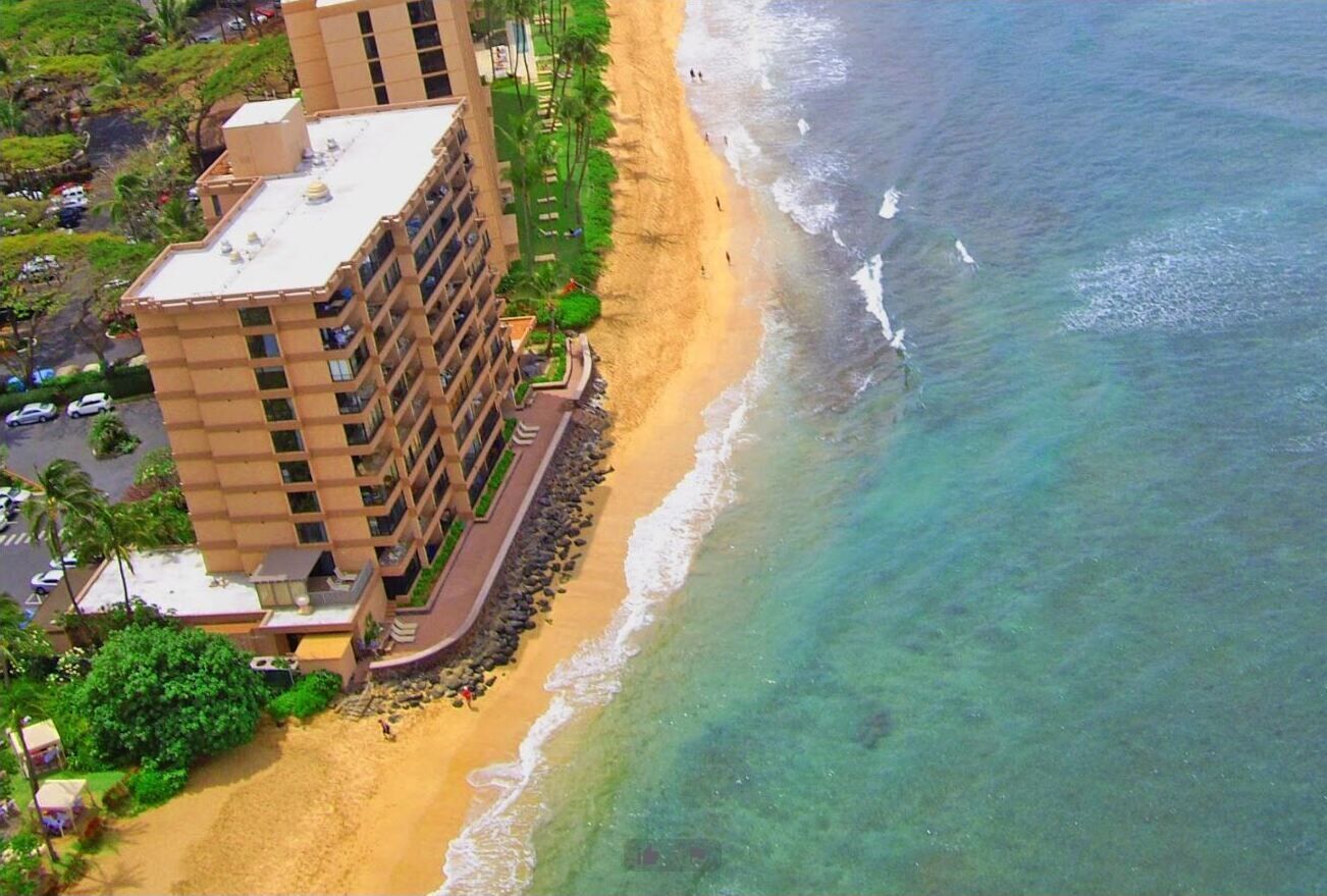 A high-rise hotel with multiple floors, a beachside location, and a clear view of the ocean.