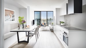 Une cuisine moderne avec un coin repas, de grandes fenêtres et une vue sur la ville.