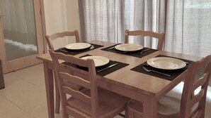 A dining table set with plates, cutlery, and black placemats. - Sand House, New Apartment (Albufeira)