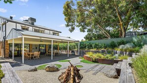 A modern house with a covered patio, outdoor seating, and a fire pit. - Port of Call (Port Willunga)