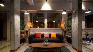 Uma sala de estar moderna com um sofá preto, uma mesa de centro de madeira e duas luminárias de chão.