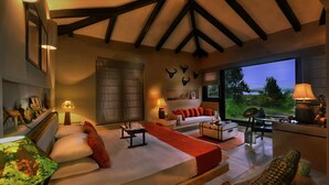 A cozy room with a bed, sofa, and a view of the outdoors. - Pugdundee Safari- Denwa Backwater Escape (Sohagpur)