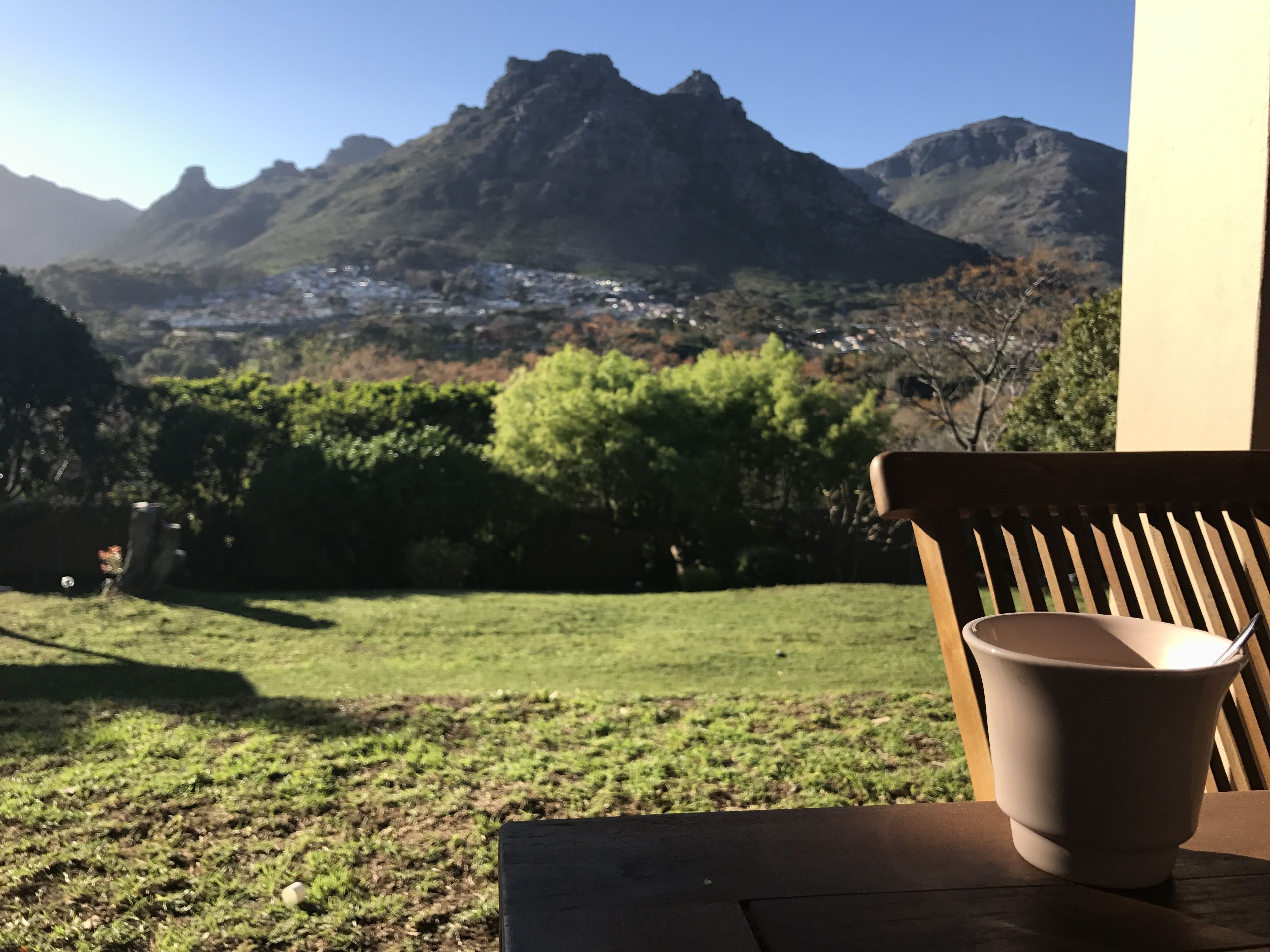 A patio with a view of mountains and a town in the distance.