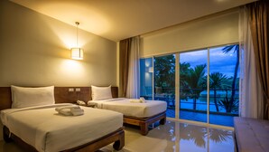 A hotel room with two beds, a balcony with a pool view, and a well-lit ceiling lamp. - Tamali Hotel (Phra Phrom)
